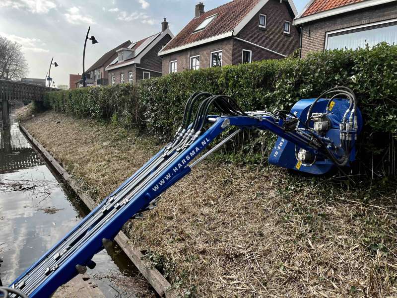 Talud onderhoud vanaf het water, met het rupsvoertuig, uitgerust met een maaiarm. Werk in uitvoering.