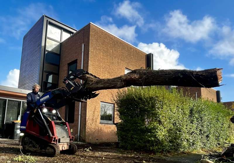 Rupsvoertuig met bomenklem, werk in uitvoering.