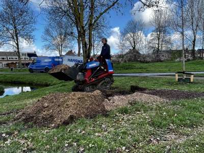Machinaal opruimen van houtpulp in Spijkenisse.