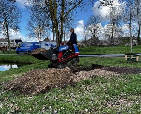 Machinaal opruimen van houtpulp in Spijkenisse.