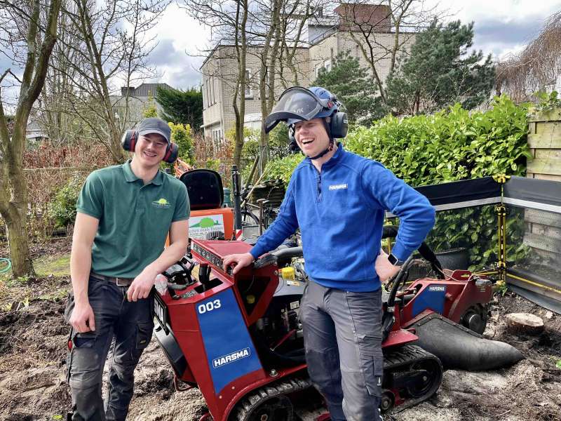 Boomstronk verwijderen in een achtertuin in Rotterdam, door het gebruik van een stronkenfrees machine, samen met een collega hoveniersbedrijf.